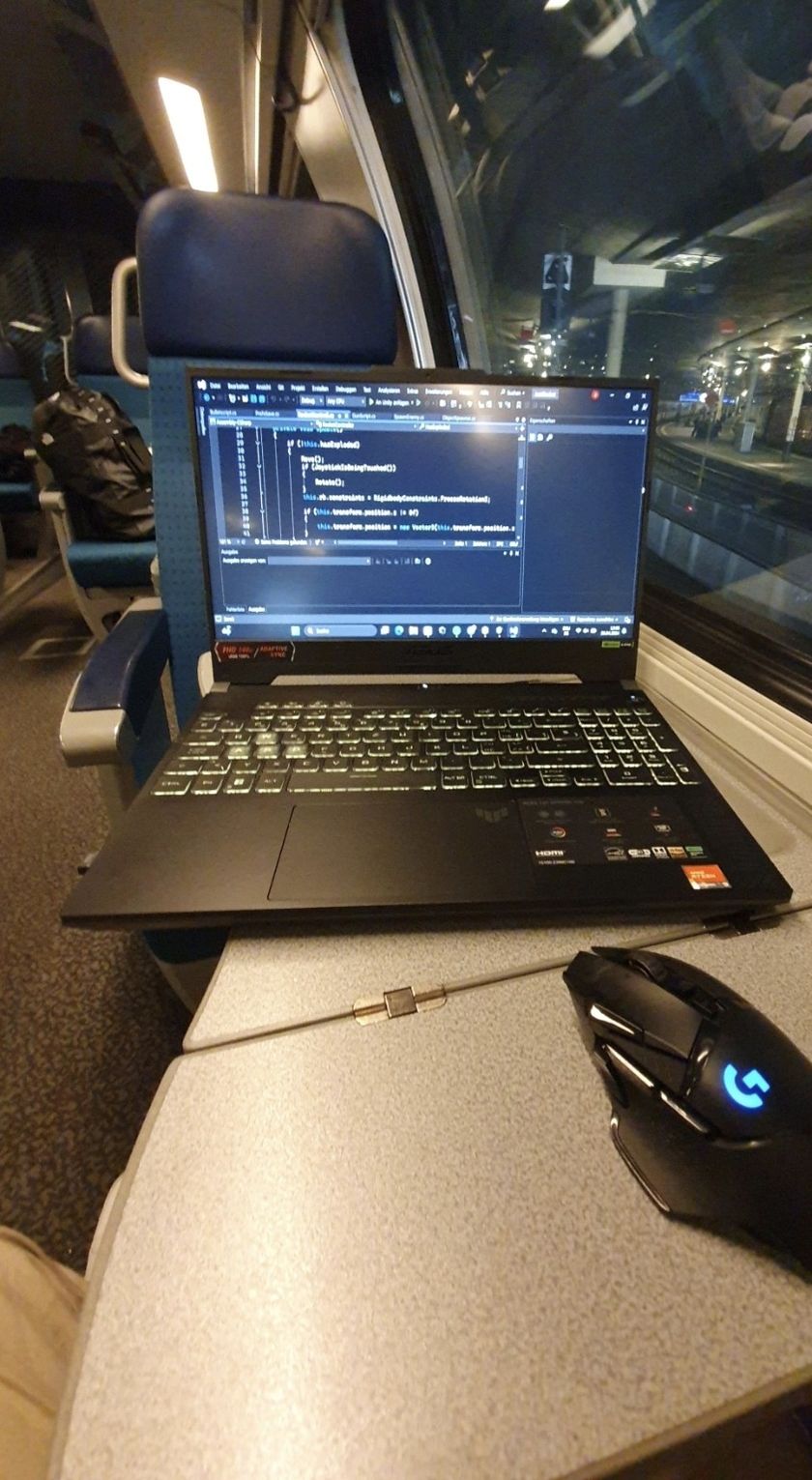 Laptop mit geöffnetem Code-Editor auf dem Klapptisch im Zug